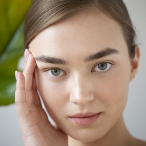 portrait-beautiful-woman-with-clear-skin-posing-with-monster-plant-leaf